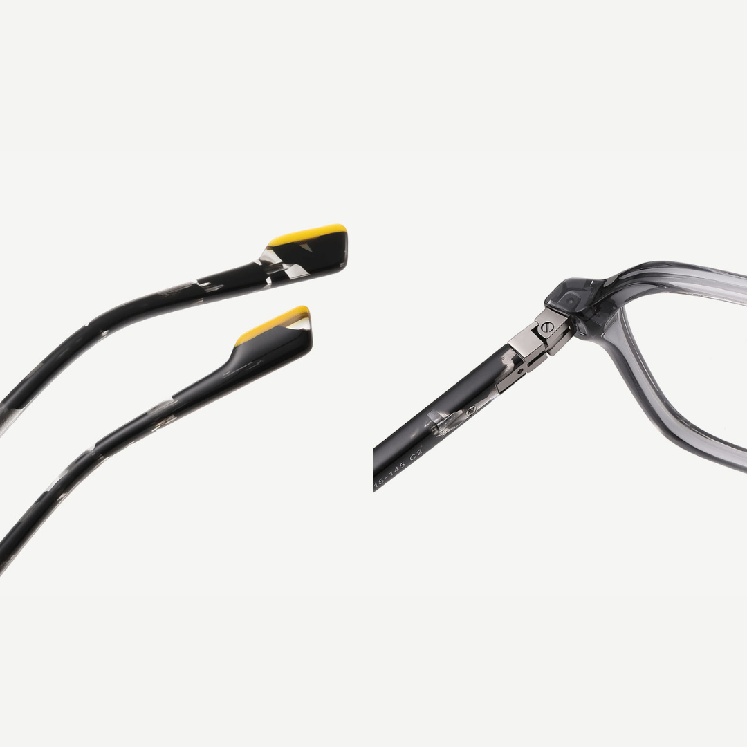 Close-up of a pair of eyeglasses with black frames and yellow accents on a white background.